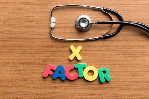 x factor colorful word with stethoscope on wooden background